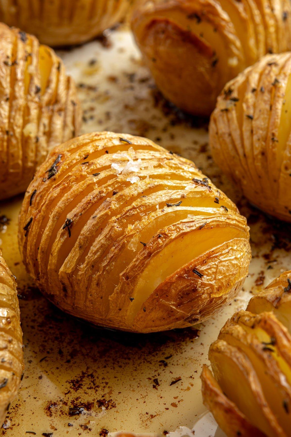 Fertig gebackene, goldbraune Kartoffeln liegen auf einem Backblech. Grobes Salz ist darüber gestreut.
