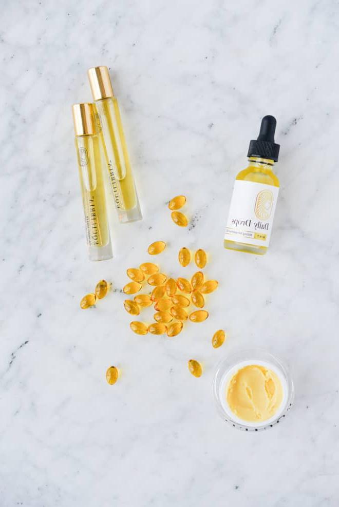 equilibria cbd tropfen, roll-ons, creme und weichkapseln auf einer marmoroberfläche