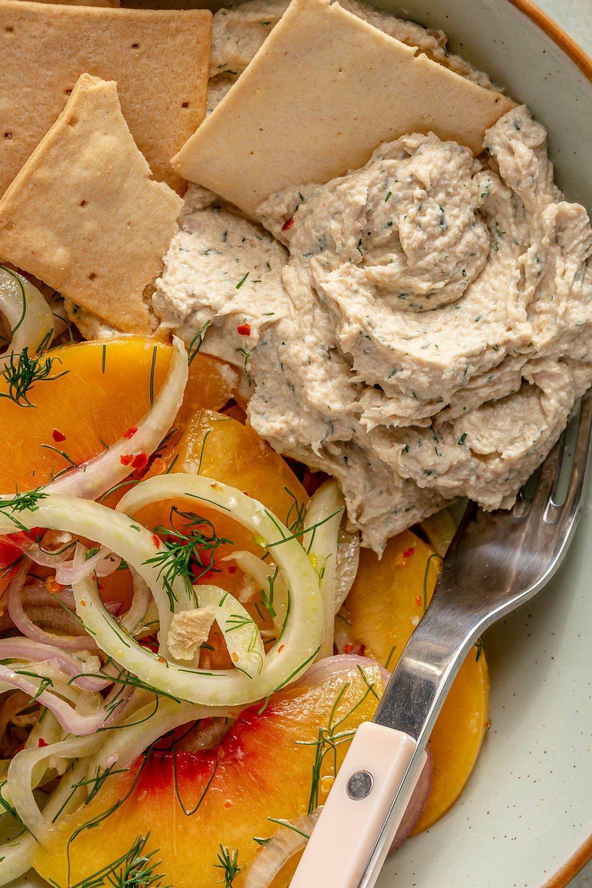 Ein samtig-glatter Zitronen-Dill-Hähnchensalat, serviert neben einem Nektarinensalat und Crackern.