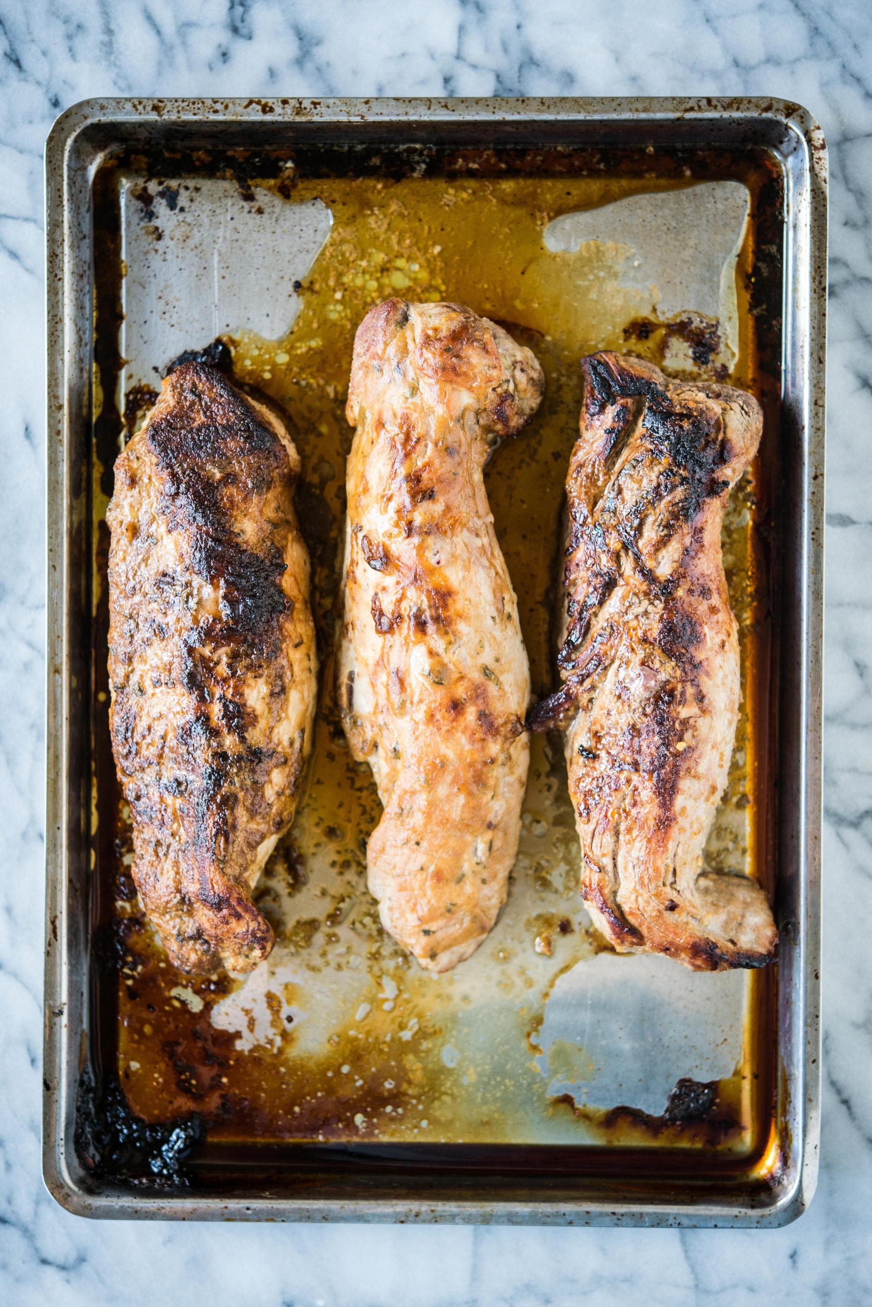 3 gebackene Schweinefilets auf einem Edelstahlblech