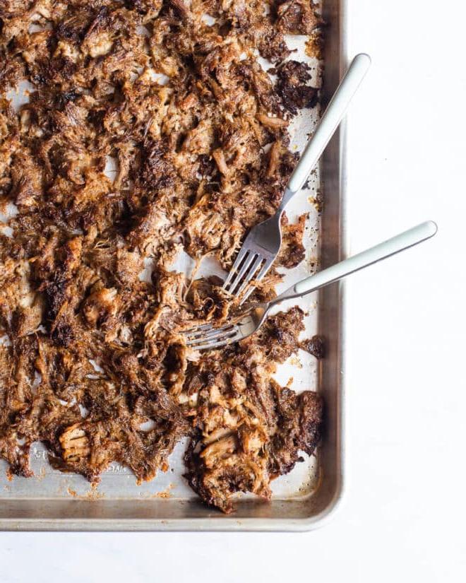 Instant Pot Carnitas Tacos 2 Knusprige Schweinefleisch-Carnitas auf einem Backblech mit zwei Gabeln daneben
