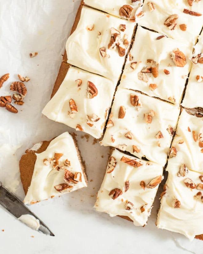 Das beste hausgemachte Gewürzkuchenrezept aller Zeiten 2 Ein glasierter Gewürzkuchen mit Pekannüssen belegt, in 12 Portionen geschnitten auf Backpapier
