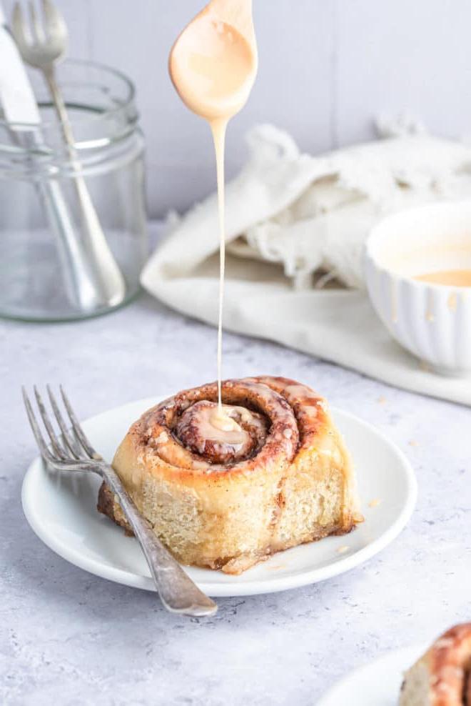 Eine vegane Zimtschnecke, beträufelt mit Vanille-Bourbon-Glasur