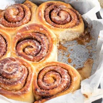Ein Blech mit Vanille-Zimtschnecken, beträufelt mit Vanille-Bourbon-Glasur
