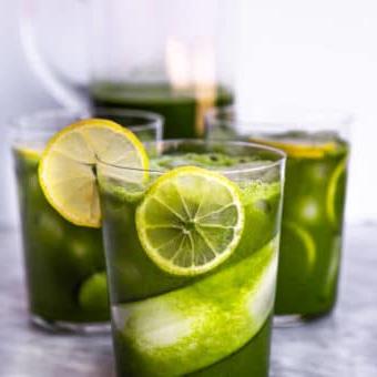 Drei Gläser, mit Gurken- und Zitronenscheiben ausgekleidet, mit Eis und Saft.