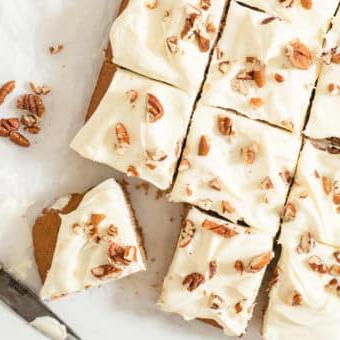 Das beste hausgemachte Gewürzkuchenrezept aller Zeiten 5 Ein glasierter Gewürzkuchen mit Pekannüssen belegt, in 12 Portionen geschnitten auf Backpapier