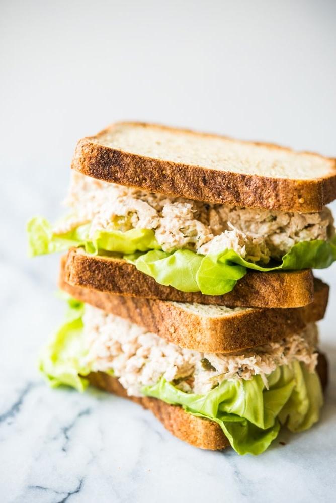 Klassische Thunfischsalat-Sandwiches übereinander gestapelt auf einem Marmorbrett