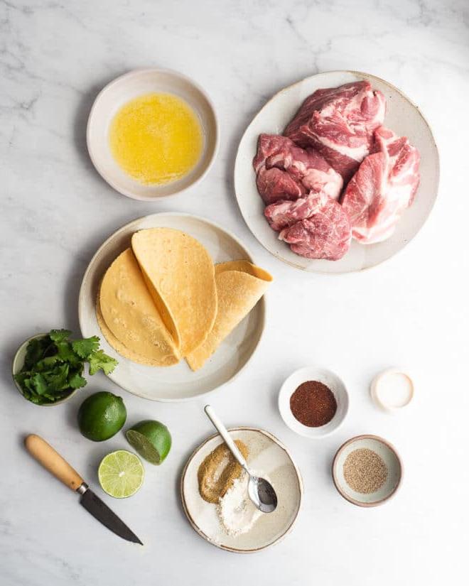 Instant Pot Carnitas Tacos 3 Die Zutaten für Instant Pot Schweinefleisch-Carnitas auf einer Marmoroberfläche