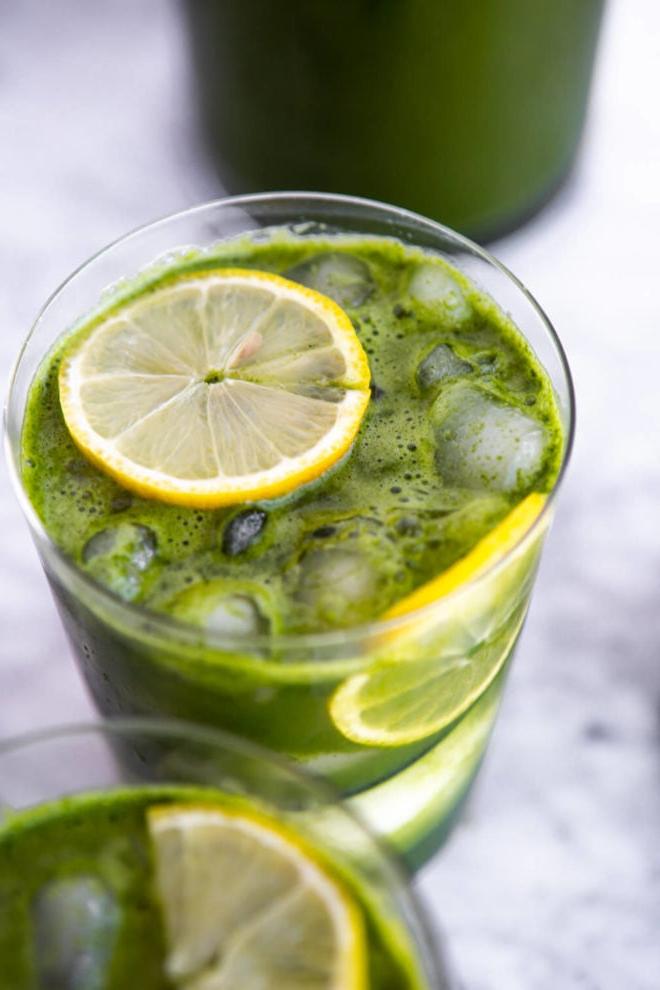 Grüner Saft in einem Glas, von oben betrachtet, mit einer Zitronenscheibe garniert.