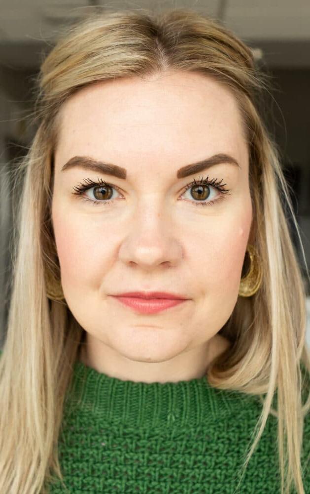 Nahaufnahme von Lauren, die einen kellygrünen Pullover trägt und nicht lächelt.