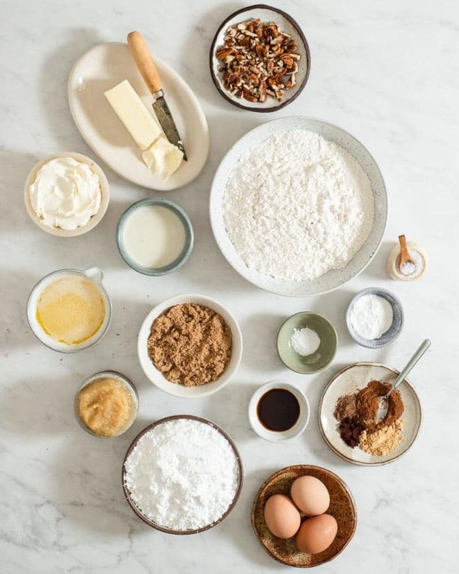 Das beste hausgemachte Gewürzkuchenrezept aller Zeiten 3 Alle Zutaten für Gewürzkuchen in verschiedenen Schüsseln auf einer Marmoroberfläche