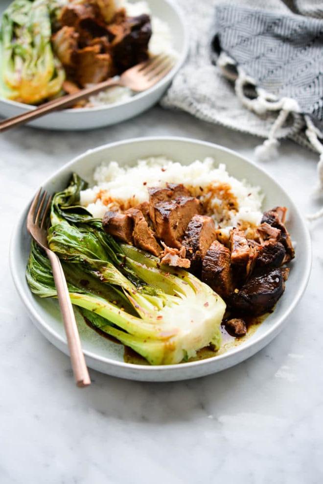 Zwei flache Schüsseln mit weißem Reis, Teriyaki-Schweinefilet und Pak Choi