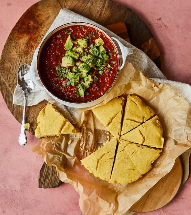 Vegetarisches Chili neben einer Portion veganem Maisbrot
