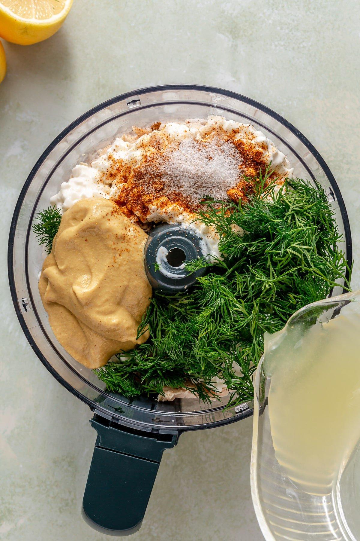 Alle Zutaten für den Zitronen-Dill-Hähnchensalat in einer Küchenmaschine, bevor sie vermischt werden.