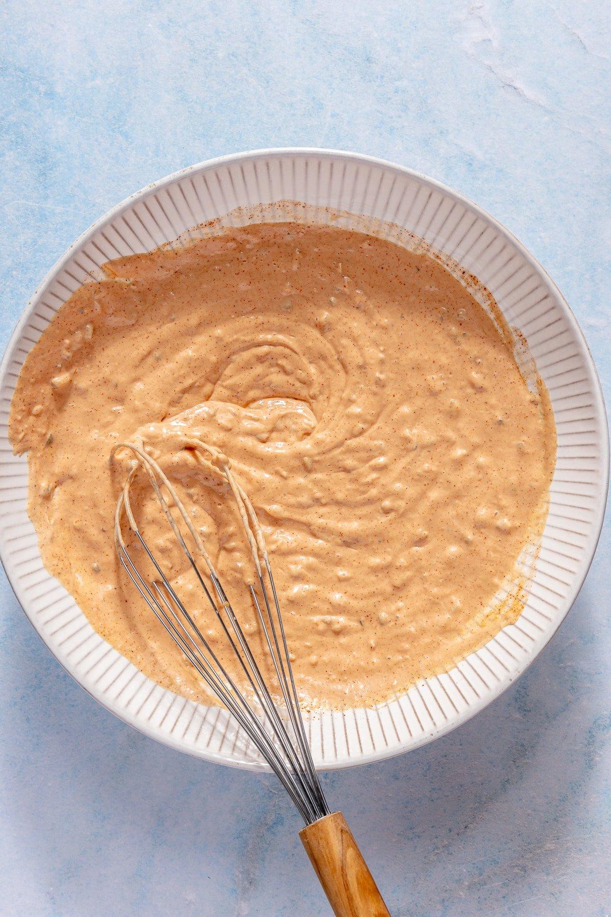 Burgersauce wird in einer weißen Schüssel verrührt.