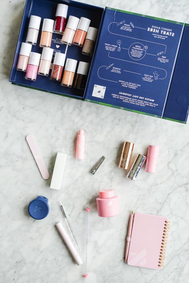 Olive & June blaue Box mit verschiedenen Nagellacken und anderem Nagelzubehör auf einer Marmoroberfläche.