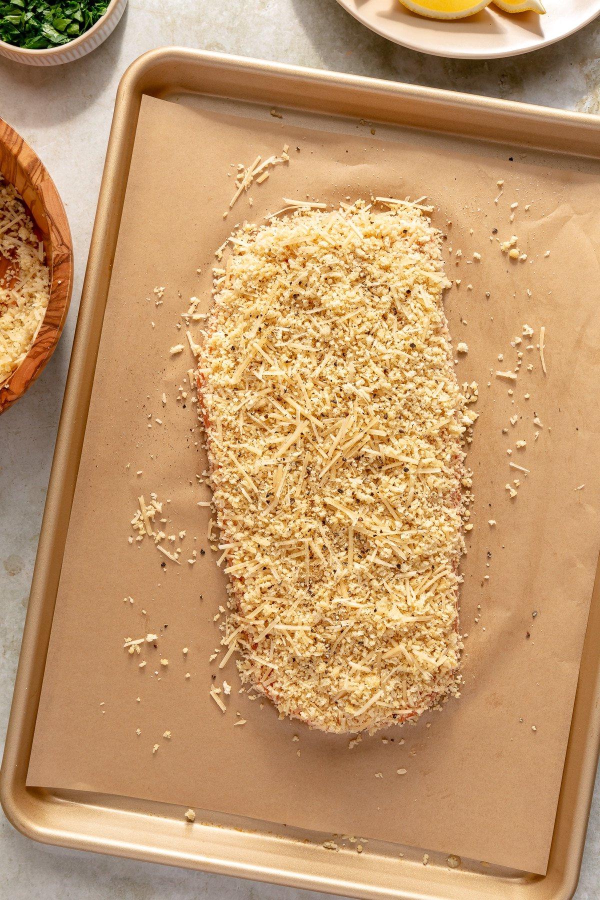 Die Parmesan-Panko-Mischung wird gleichmäßig auf das Lachsfilet aufgetragen und angedrückt.