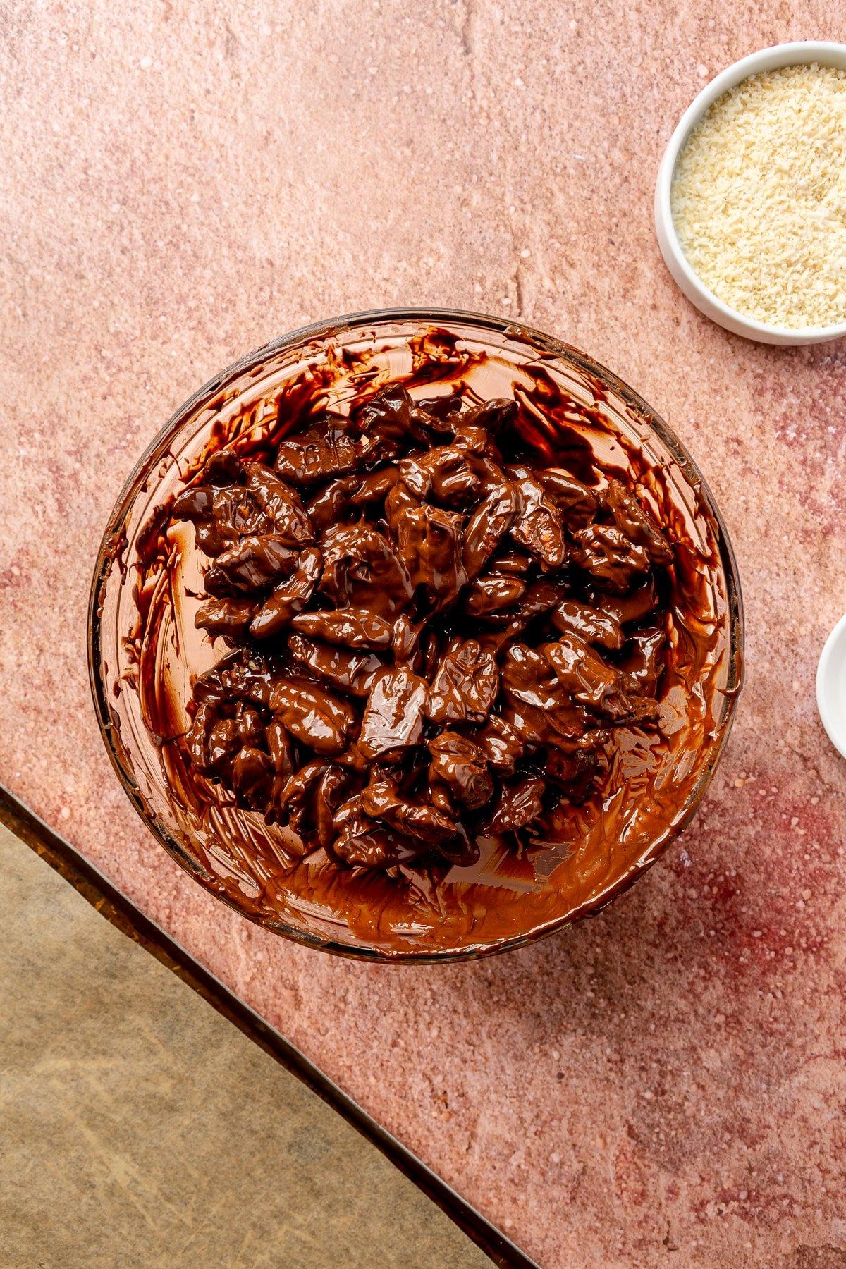 Dunkle Schokolade-Chili-Pekannuss-Brocken 6 Ganze Pekannus-Hälften werden in die Schüssel mit der geschmolzenen Schokoladen-Chili-Mischung gegeben.