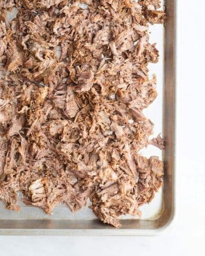 210414_Carnitas-31 Ein Backblech mit gewürztem, zerkleinertem Schweinefleisch, bevor es in den Ofen kommt, um Carnitas zu machen