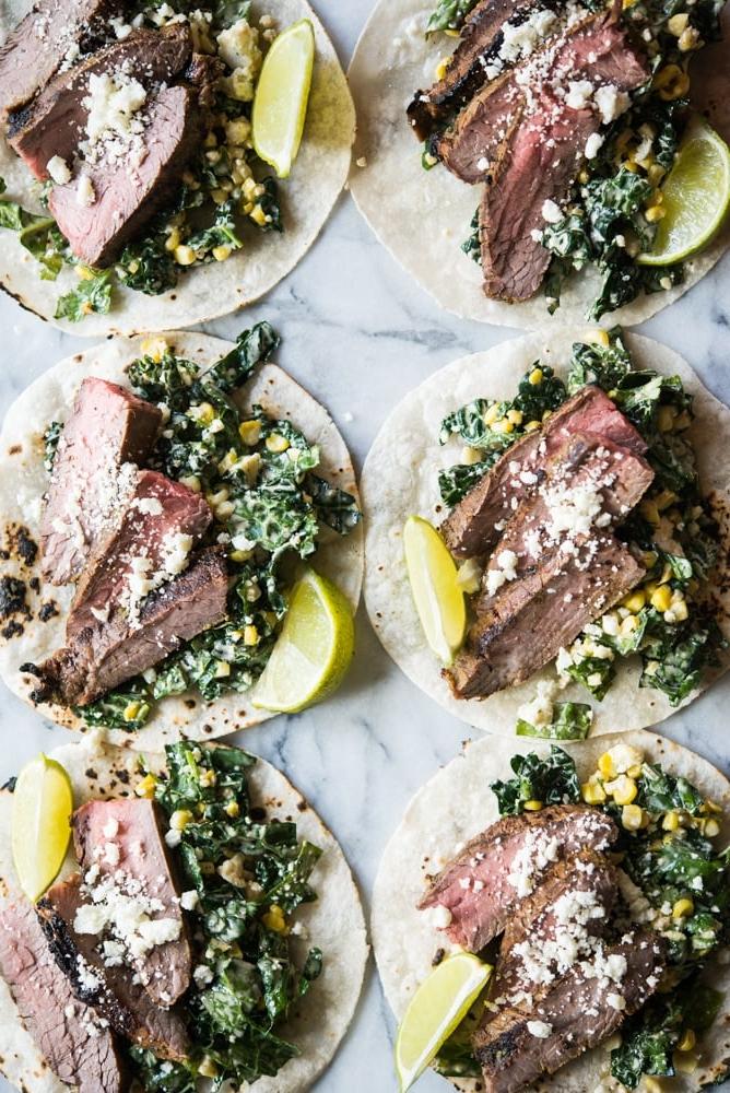 Rindfleisch Carne Asada auf Grünkohl und Krautsalat in einer Maistortilla auf einem Marmorbrett