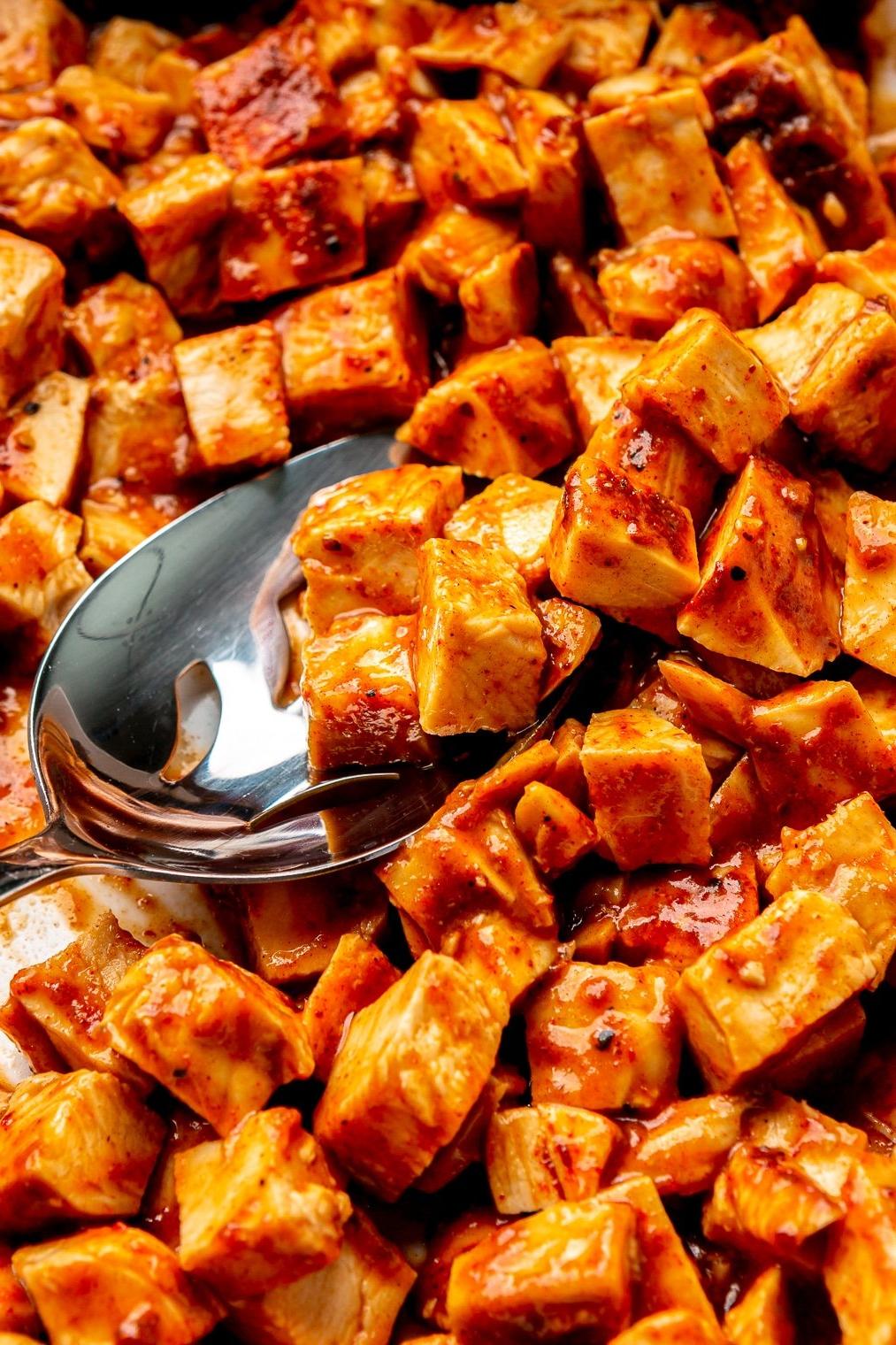 Nahaufnahme von gewürfelten gebackenen BBQ-Hähnchenbrüsten.