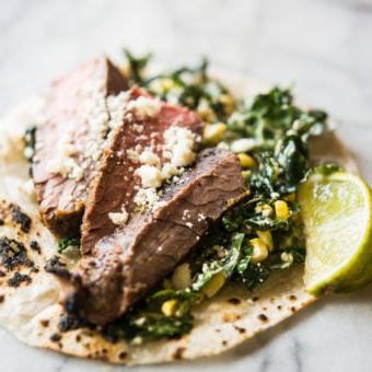 Rindfleisch Carne Asada auf Grünkohl und Krautsalat in einer Maistortilla auf einem Marmorbrett