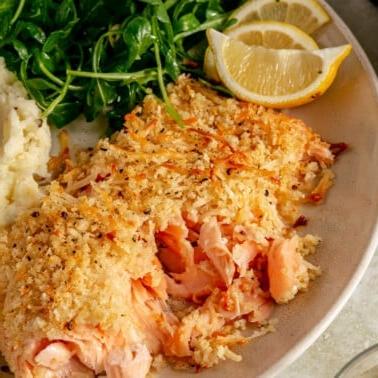 Detailansicht eines perfekt gebackenen Lachsfilets mit Parmesan-Kruste.