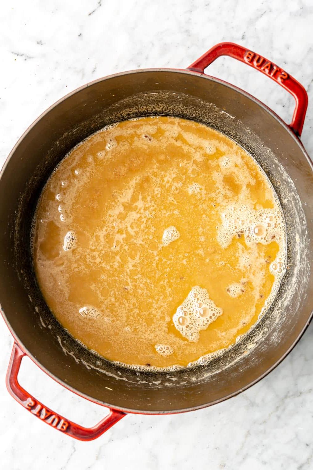 Eine Roux, die zu einer karamellfarbenen, erdnussbutterfarbenen Farbe in einem großen holländischen Ofen gekocht wurde.
