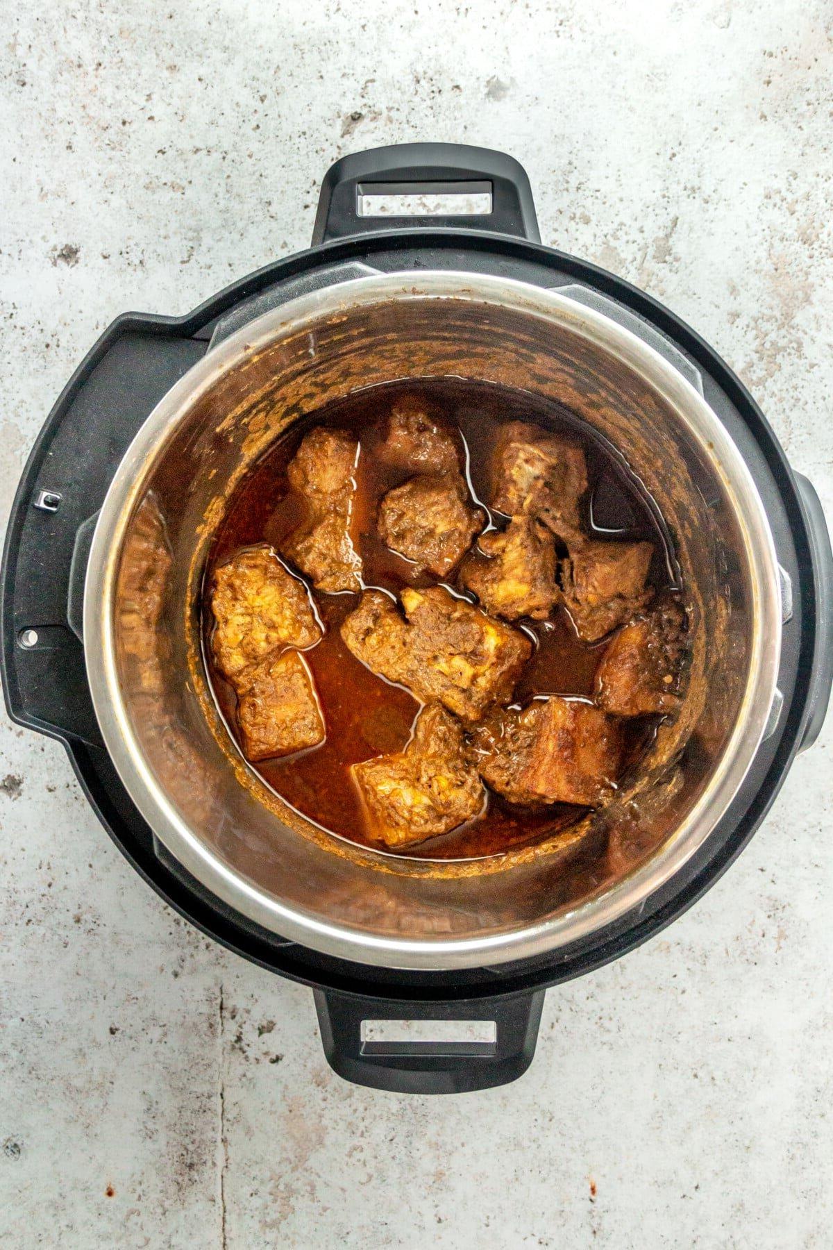 Gekochte, perfekt zarte Stücke von mariniertem Schweineschulterfleisch im Slow Cooker nach dem Garvorgang.