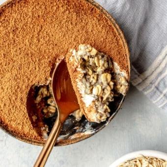 Draufsicht auf eine Schale Overnight Oats, aus der ein Löffel voll entnommen wurde.